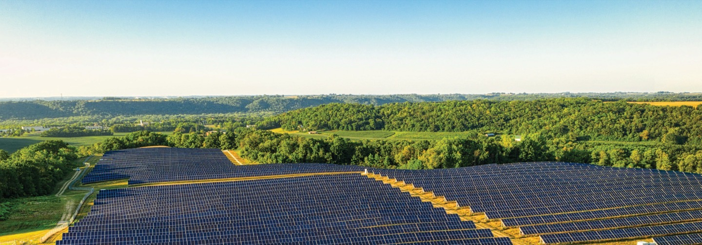 Ground-mounted solar array across open countryside