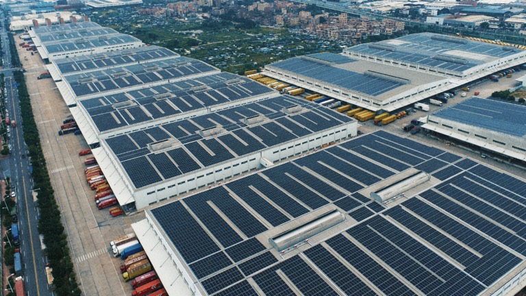 Aerial view of an industrial rooftop array above loading bays